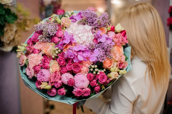 Visão traseira de uma menina com um buquê de flores — Fotografia de Stock