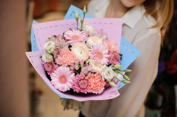 Blond kvinna klädd i en vit blus med en bukett blommor — Stockfoto