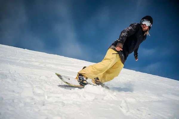 Сноубордист, спускающийся по склону горы — стоковое фото