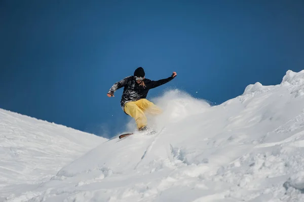 Freeride snowboarder no salto em altas montanhas no dia ensolarado — Fotografia de Stock
