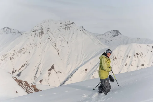 Улыбающийся мужчина-сноубордист на фоне горных вершин — стоковое фото
