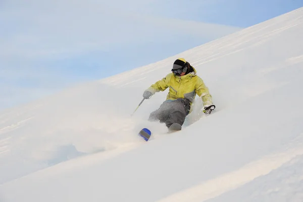 Jogador de snowboard masculino ativo descendo a encosta nevada — Fotografia de Stock