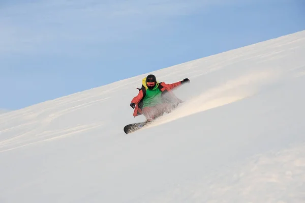 Ενεργό snowboarder ιππασία κάτω από την χιονισμένη πλαγιά — Φωτογραφία Αρχείου