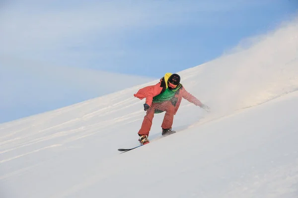 Snowboarder ativo montando na encosta nevada — Fotografia de Stock