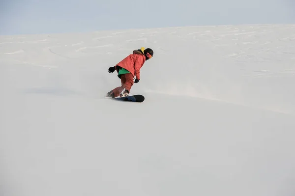 Profissional snowboarder masculino deslizando na encosta da montanha — Fotografia de Stock