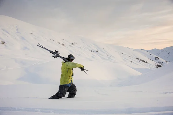 Vista lateral do snowboarder masculino profissional que anda nas montanhas — Fotografia de Stock