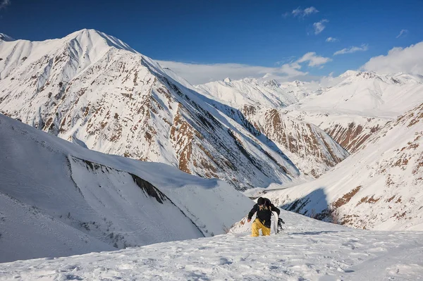 Фрирайд мужчина сноубордист, идущий по склону горы — стоковое фото
