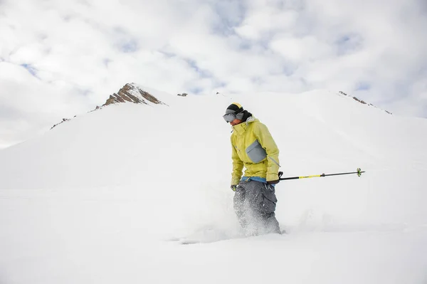 Фрирайд сноубордист, одетый в желтую спортивную одежду — стоковое фото