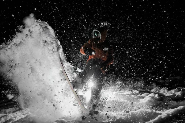 Freeride-Snowboarder springt nachts auf dem Brett im Schnee — Stockfoto
