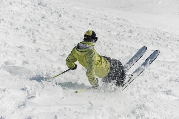 Visão traseira do esquiador freeride masculino deslizando para baixo da colina nevada — Fotografia de Stock