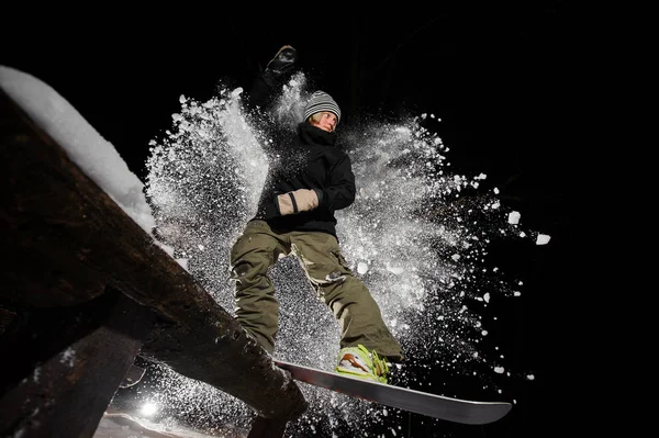 Активна жінка сноубордистка їде вниз по схилу гори вночі — стокове фото