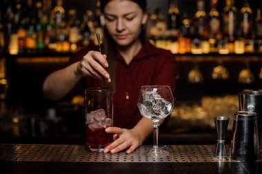 Barmen kız stiring taze bir ışık kırmızı kokteyl