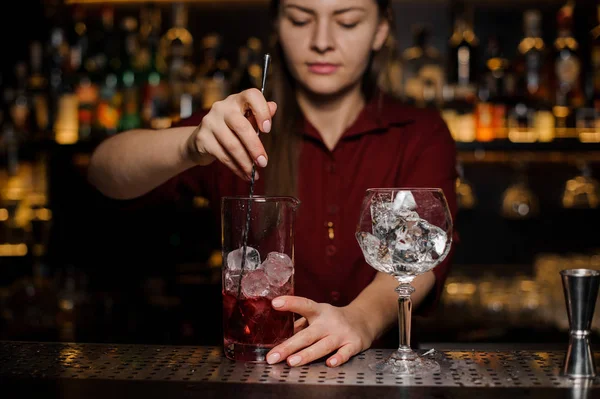 Garçonete fazendo um cocktail vermelho claro fresco — Fotografia de Stock