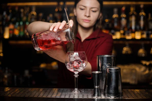 Garota barman derramando um coquetel vermelho luz fresca — Fotografia de Stock