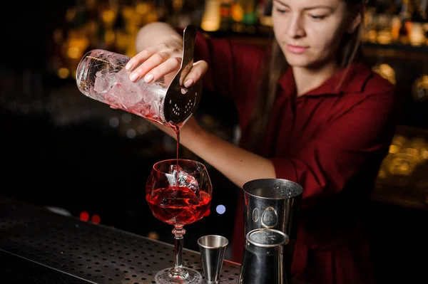 Barkeeper-Mädchen gießt einen hellroten Cocktail — Stockfoto