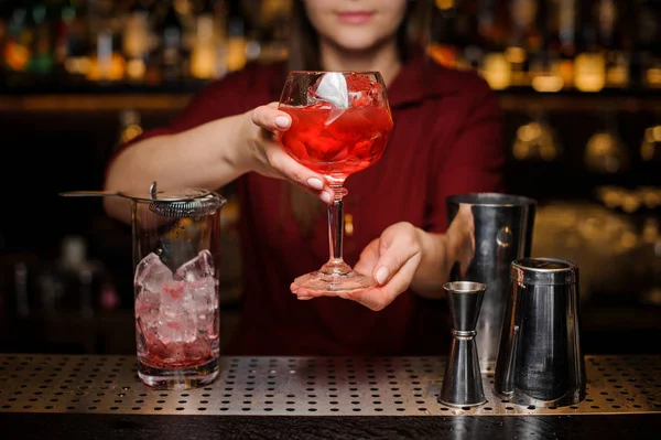 Meisje van de barman serveert een licht rode cocktail — Stockfoto