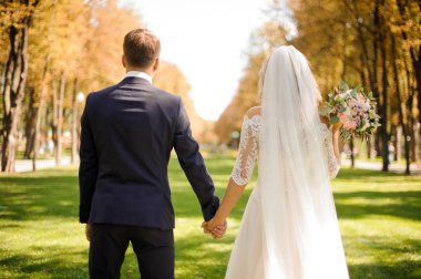 Arkadan gelin ve damat el ele tutuşarak görünüşü