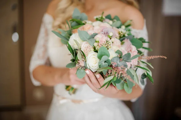 Noiva em um vestido branco segurando um buquê de casamento — Fotografia de Stock