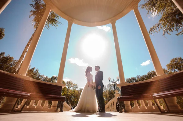 Foto vista inferior da noiva e noivo em pé em rotunda — Fotografia de Stock