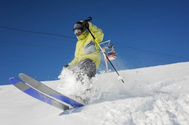 Gudauri, Gürcistan'daki füniküler arka plan üzerinde dağ yokuş aşağı çalışan kayakçı