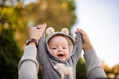 Babası bir sevimli gülümseyen küçük oğlu Park yükselterek eller