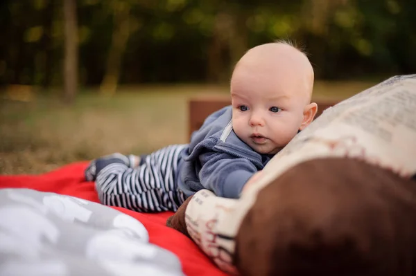 Malý chlapeček ležet na dece v parku — Stock fotografie