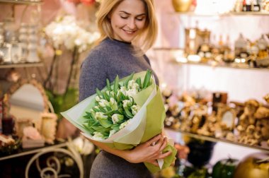 Beyaz Lale büyük bir buket tutan gülümseyen kadın