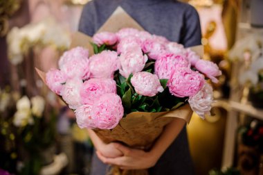 Pembe peonies büyük bir buket tutan kadın
