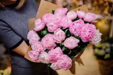 Pembe peonies güzel bir buket tutan kadın