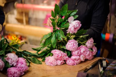 İhale pembe peonies bir buket yapma çiçekçi
