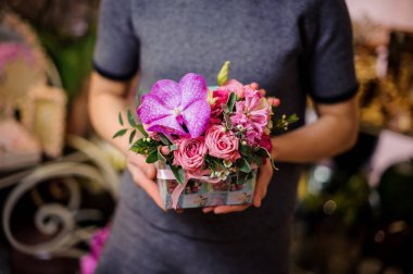 Bir kutu pembe Gül ve sümbül tutan kadın