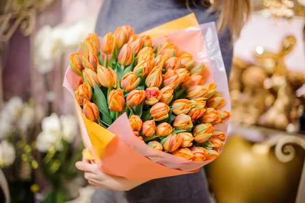 Жінка тримає великий яскравий букет помаранчевих тюльпанів — стокове фото