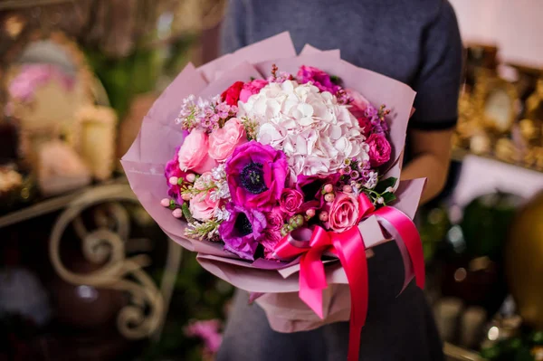 Mujer sosteniendo un hermoso ramo de diferentes flores rosadas —  Fotos de Stock