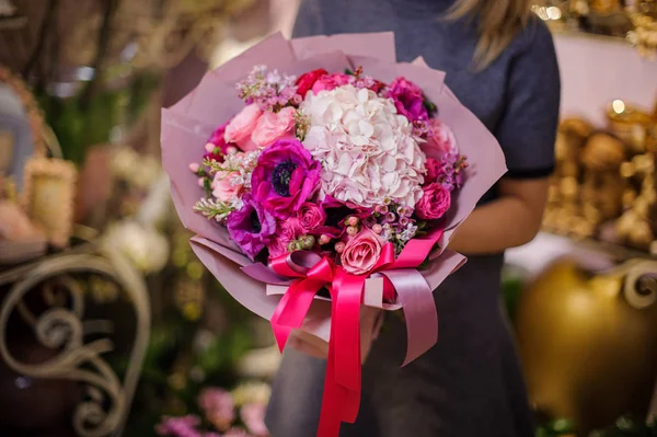 Vrouw met een mooi boeket van roze bloemen — Stockfoto