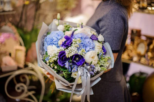 여 자가 파란과 백색 음색에서 큰 아름 다운 꽃다발을 들고 — 스톡 사진