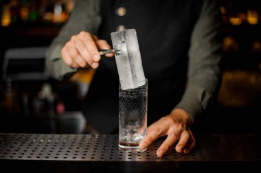 Bir cam içine buz büyük bir dikdörtgen parça koyarak barmen