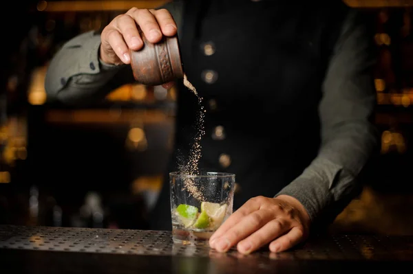 Cantinero vertiendo azúcar de caña en la copa de cóctel — Foto de Stock