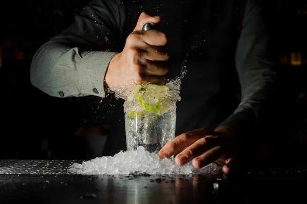 Barman exprimiendo jugo de lima fresca usando prensa cítrica y salpicándolo — Foto de Stock