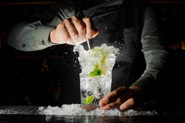 Barkeeper presst Saft aus frischer Limette mit einer Zitruspresse und spritzt ihn heraus — Stockfoto