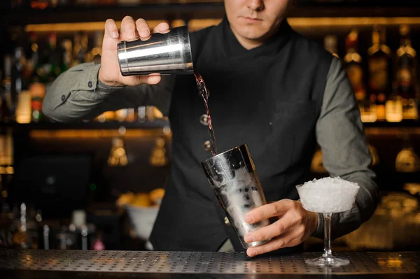 Barman mistura bebidas para fazer um coquetel — Fotografia de Stock