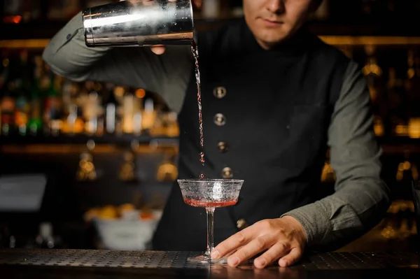 Barista versare bevanda alcolica con campari nel bicchiere da cocktail — Foto Stock
