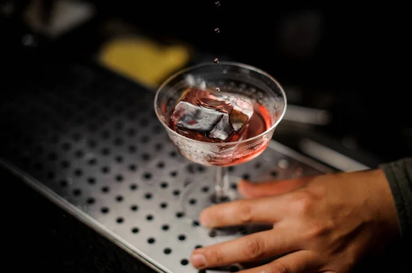 Αρσενική χέρι κρατώντας ένα ποτήρι κοκτέιλ με γλυκό αλκοολούχο ποτό — Φωτογραφία Αρχείου