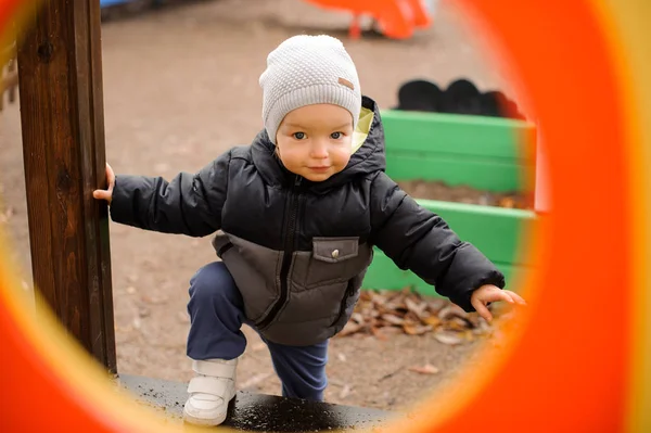 Anak kecil yang lucu mengenakan pakaian hangat dan topi berjalan di p — Stok Foto