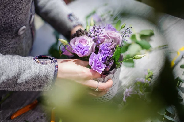 Цветочные руки делают нежный лиловый букет цветов — стоковое фото