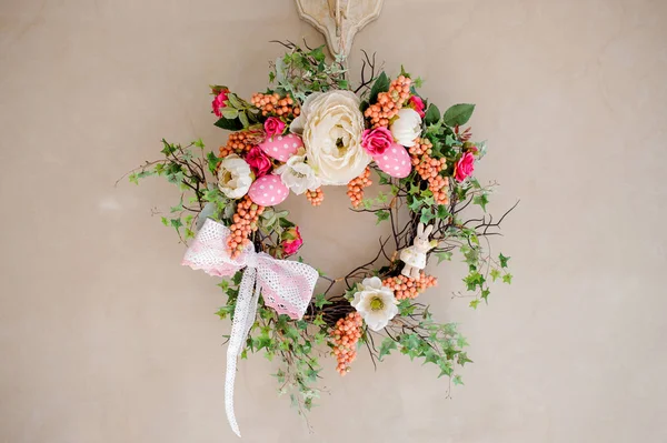 Colorful wreath with flowers, ribbon, eggs and small bunny rabbi