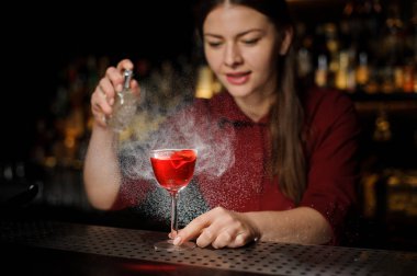 Kadın barmen lezzetli Aperol şırınga yaz lenen bir viski ile kokteyl ile dolu bir kokteyl cam yağmurlama gülümseyen