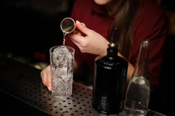 Kobiece barman leje jakiś gin do kieliszka koktajlowego — Zdjęcie stockowe