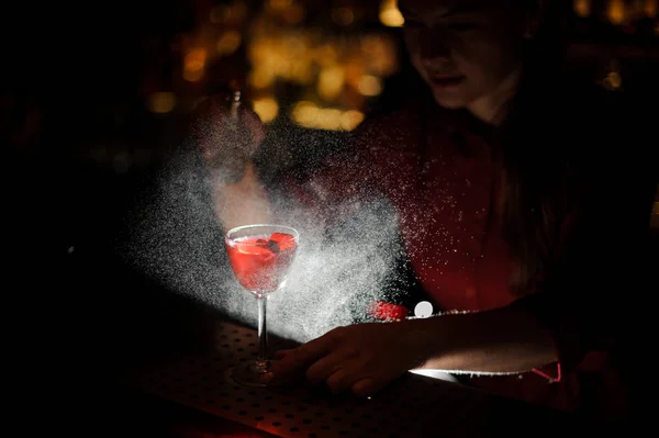 Mujer barman rociando una copa de cóctel llena de sabrosa jeringa Aperol cóctel de verano con un whisky peinado — Foto de Stock