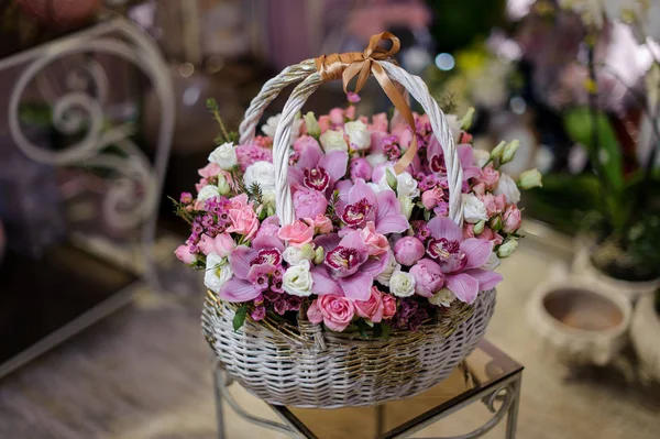 Hermosa canasta vintage blanca de orquídeas y rosas rosadas — Foto de Stock