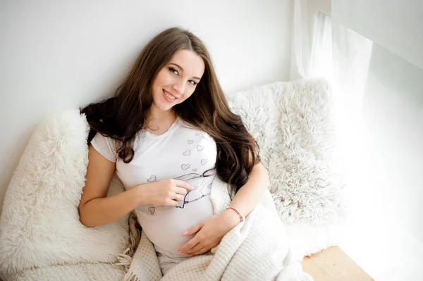 Piękne młode kobiety w ciąży, leżąc na łóżku — Zdjęcie stockowe